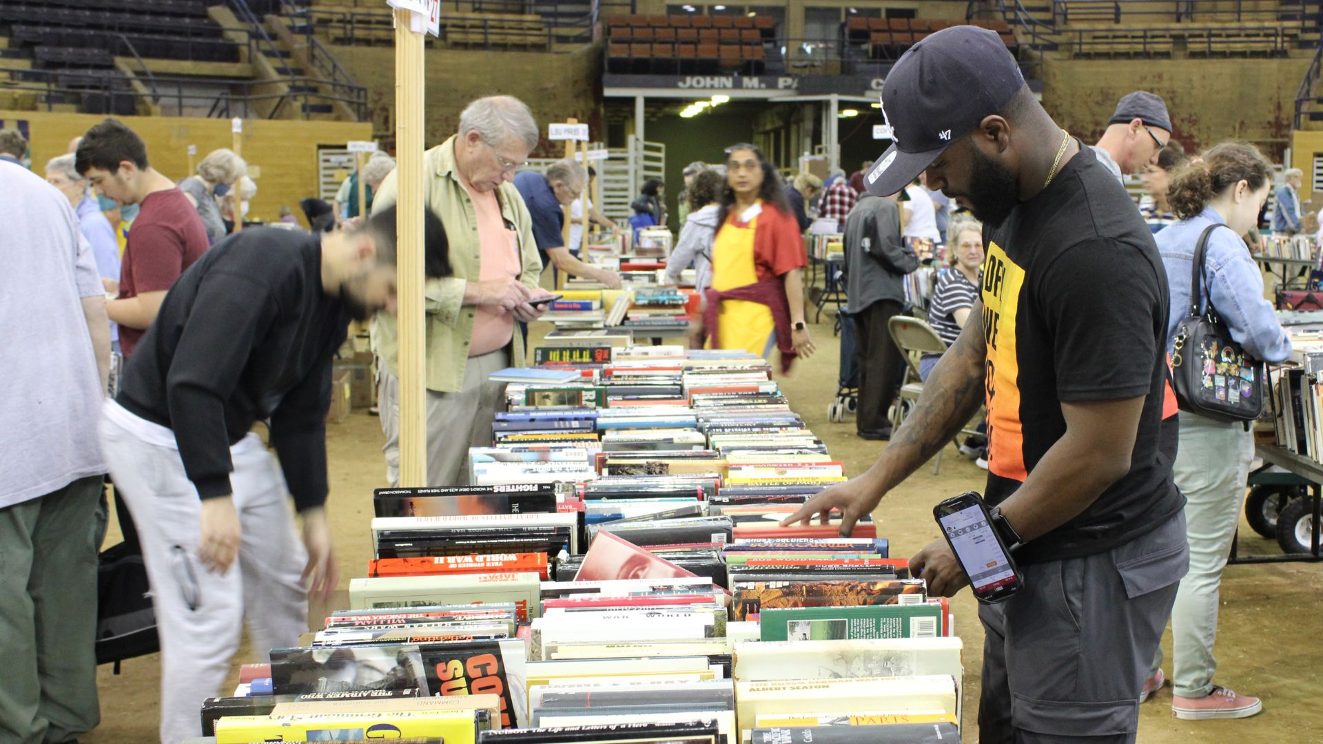 a group of people look over a long row of books