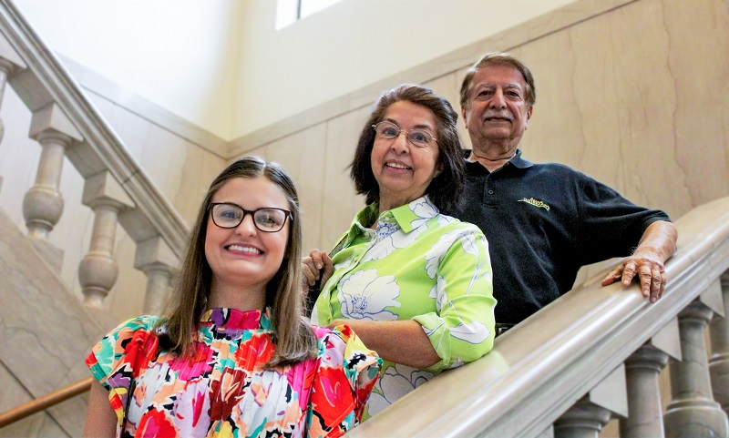 three people pose on a marble staircase