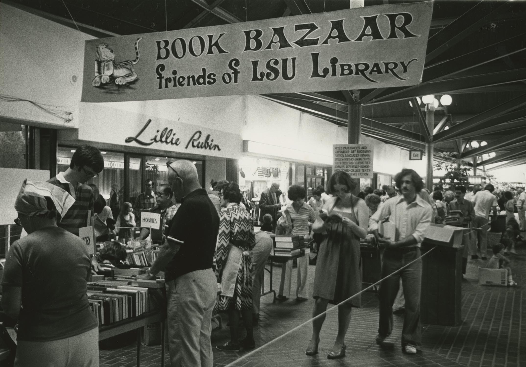 Black and white photo of shoppers browsing at the October 1977 Book Bazaar in Bon Marche Mall