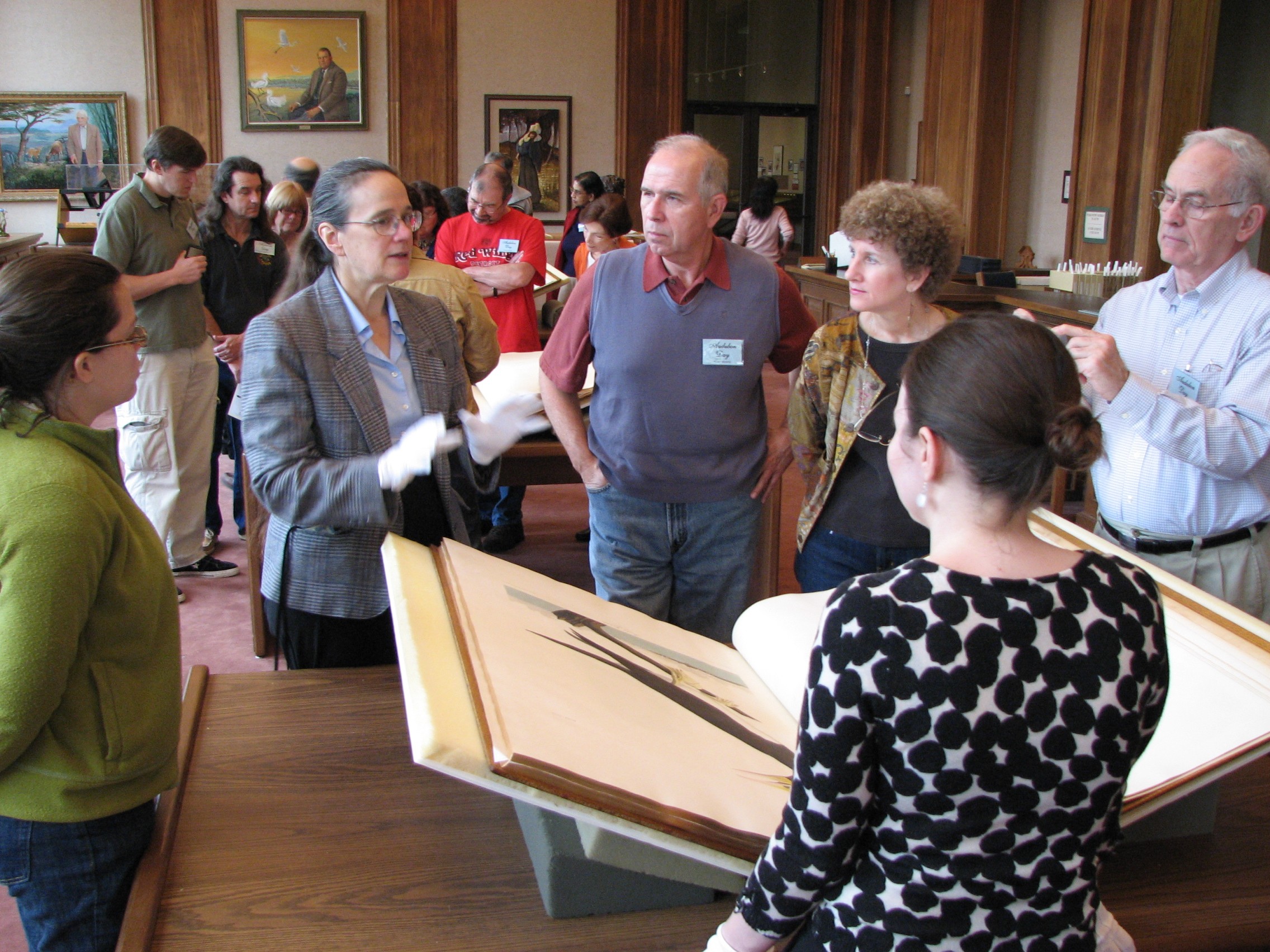 Curator Elaine Smyth answers questions while visitors view volume three