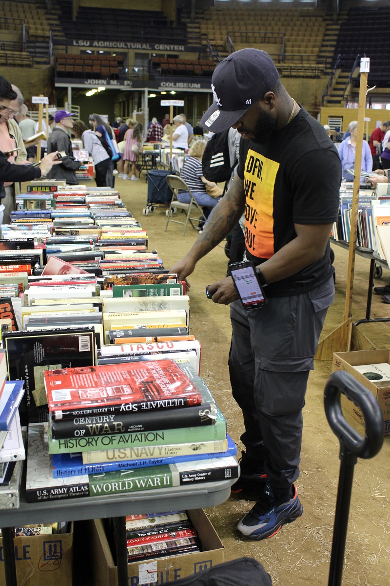 a man looks through rows of books