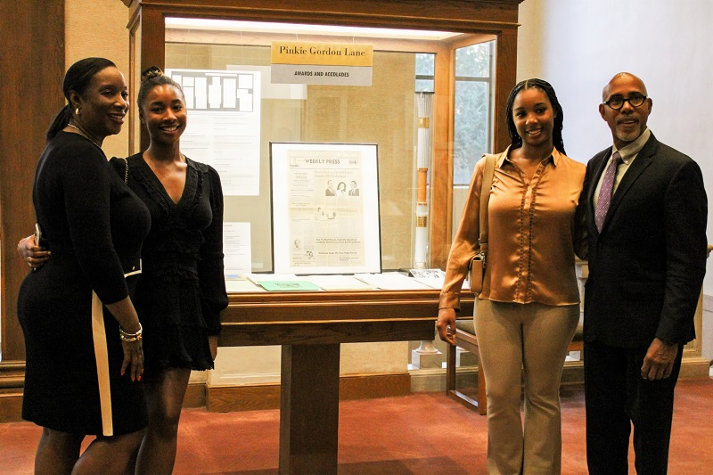 four people next to a glass display case