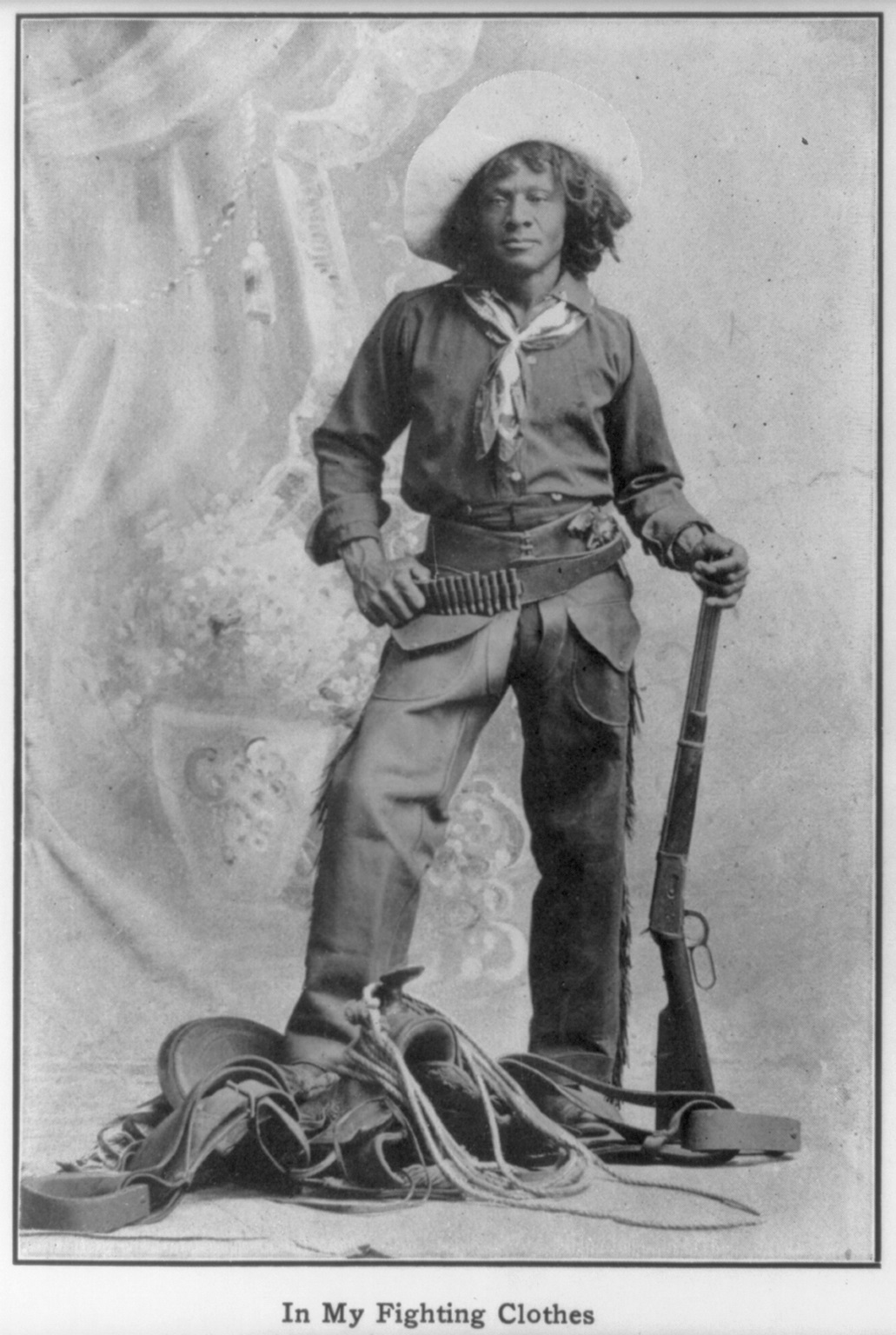 a black and white photo of a black man in cowboy attire