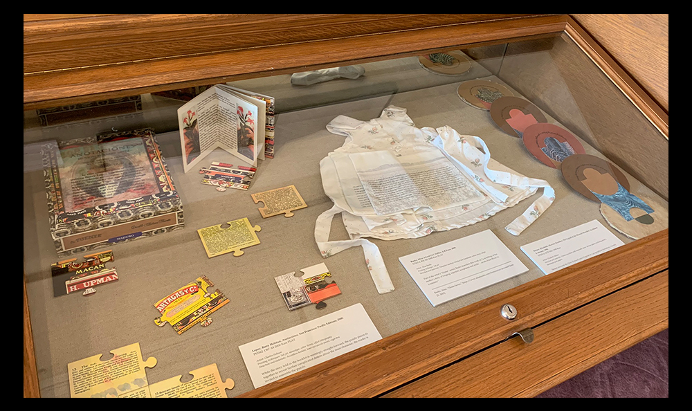 Photo of exhibition case featuring various artists' books of unusual shapes