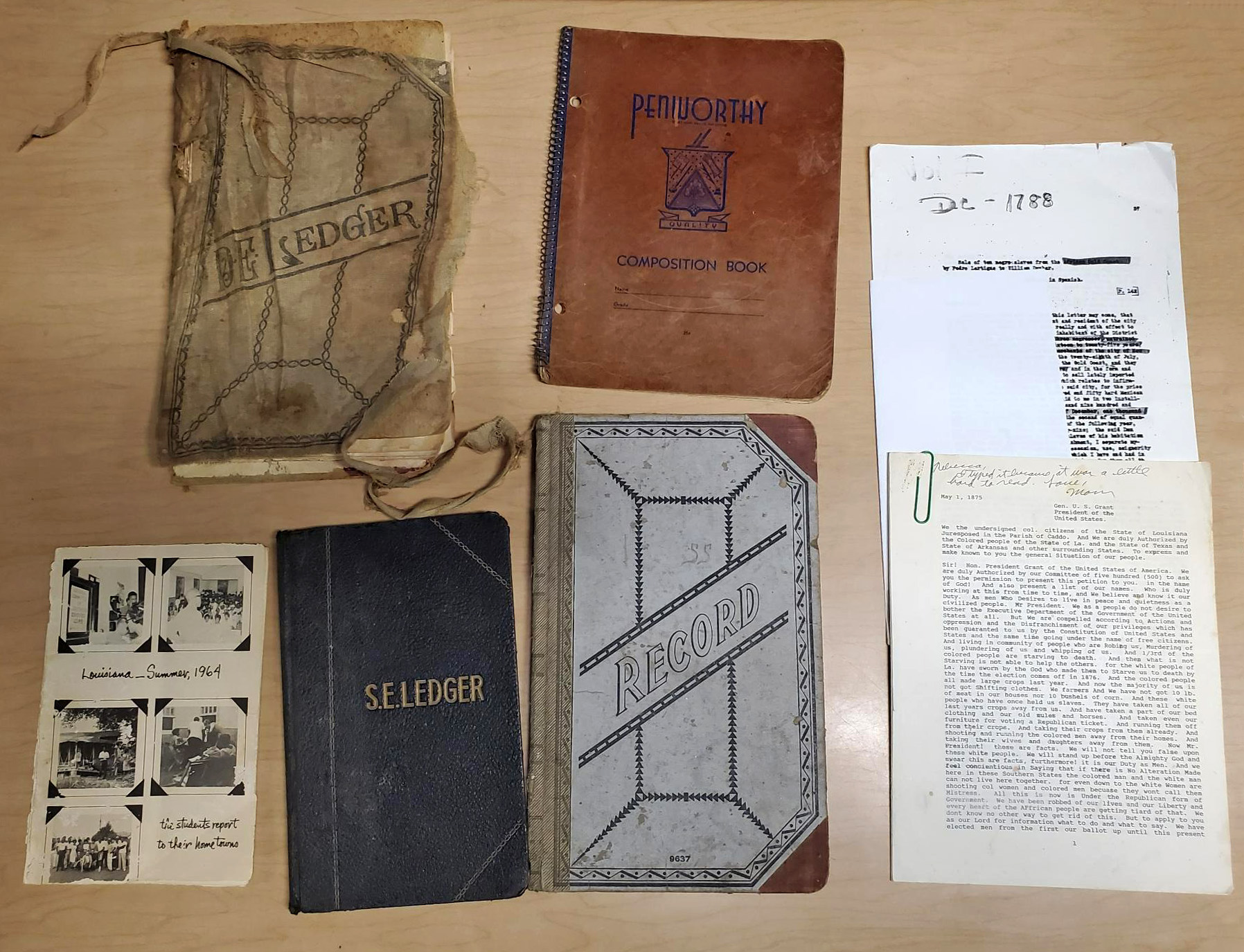 several old notebooks and some paper materials spread out on a table