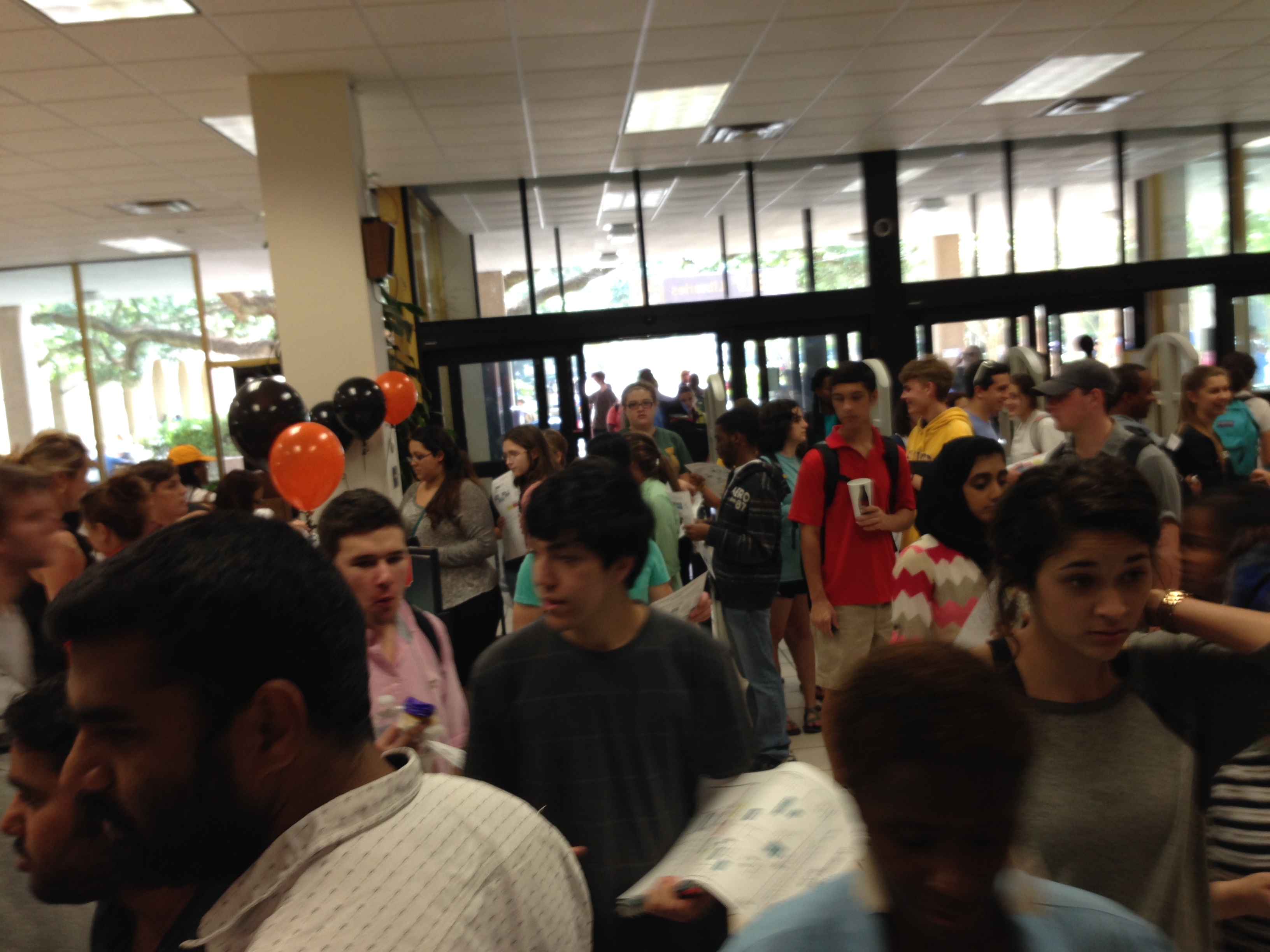 a crowd of students in the first floor lobby of the LSU library