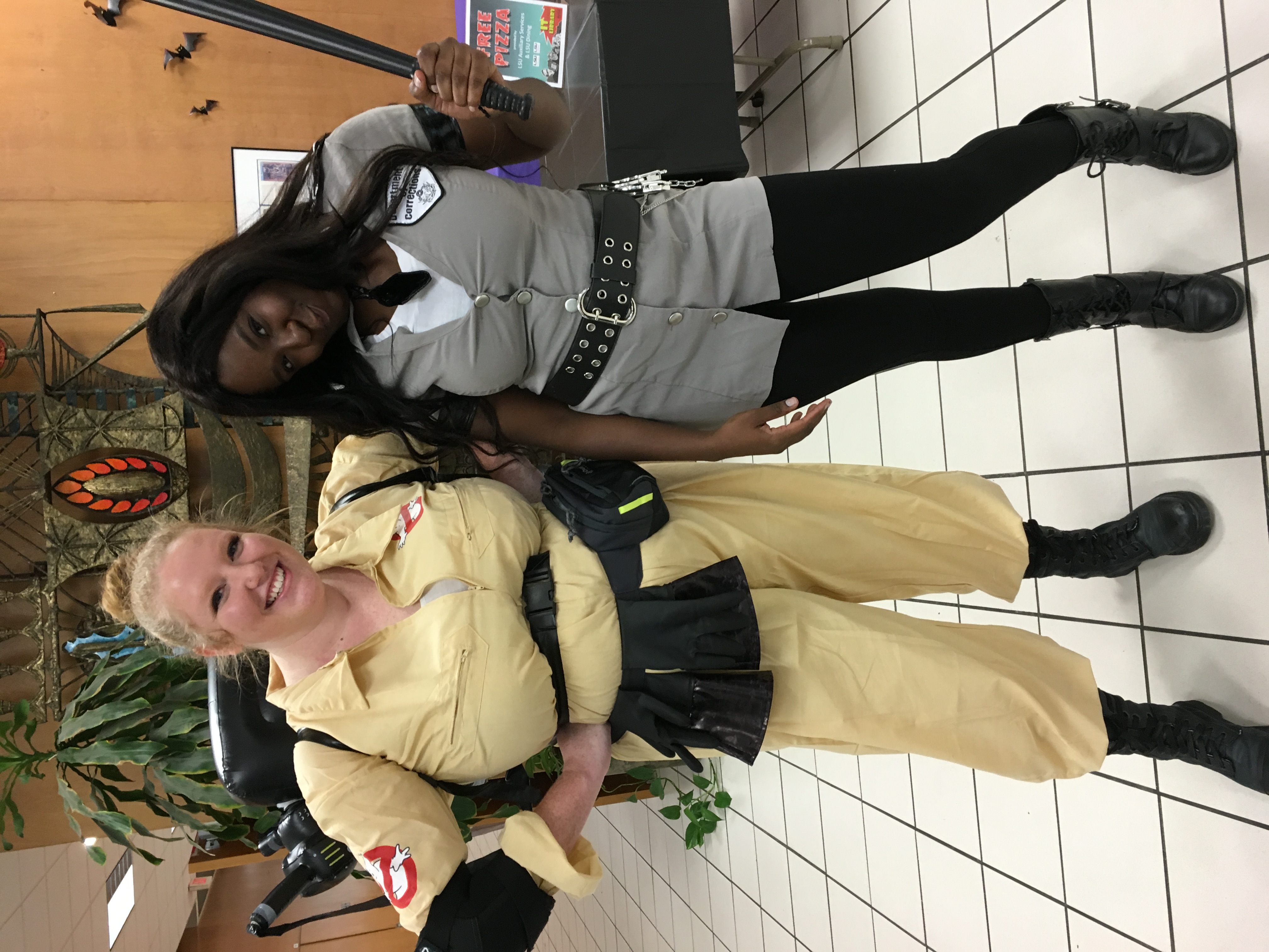 two women in costumes in the lobby of LSU library