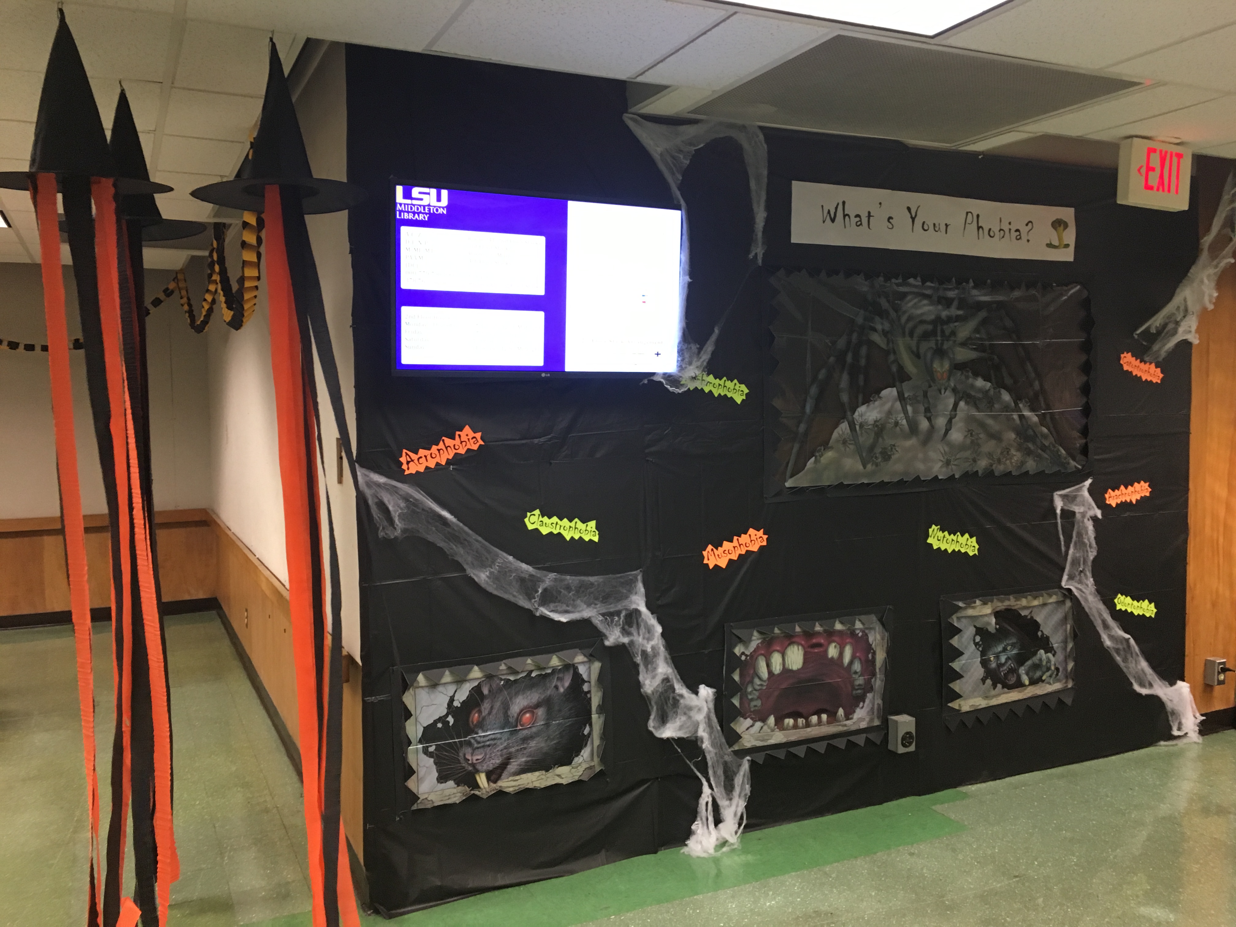 a decorated wall of LSU library reads What is Your Phobia? with pictures of spiders, rats, and other creepy things.